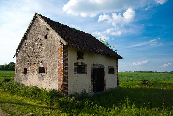 Une petite grange en bordure d'un grand champ
